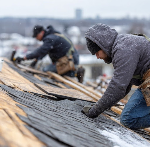  Roofing professionals working on a roof during winter conditions