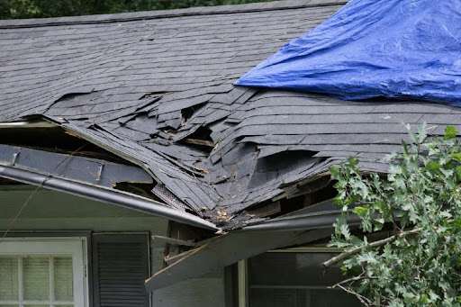 Storm-damaged roof with torn shingles and structural damage on a Pennsylvania home.
