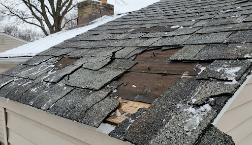 Damaged roof shingles after winter.